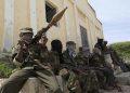 Al Shabaab soldiers sit outside a building during patrol along the streets of Dayniile district in Southern Mogadishu, March 5, 2012.