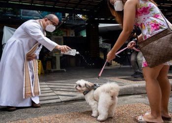 A priest sprinkles holy water at a dog at a drive-through pet blessing, ahead of World Animal Day, at a mall in Quezon City, Metro Manila, Philippines, October 2, 2022.