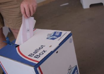 A voter putting a ballot paper into a ballot box during the 2021 Local Government Elections