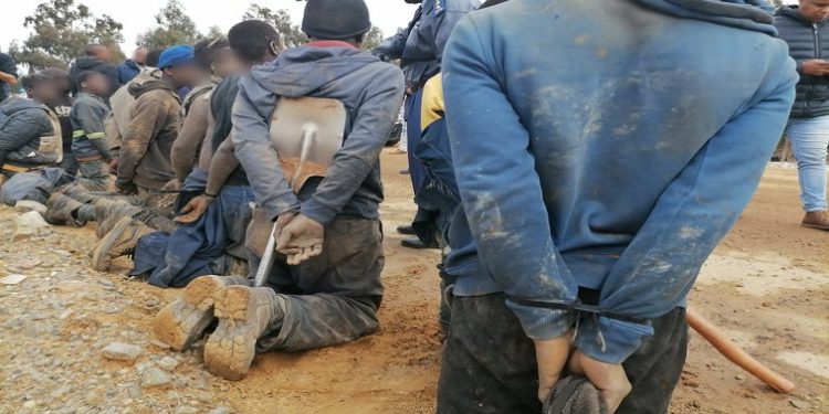 [File Image]: Illegal miners are held by police, August 2022.