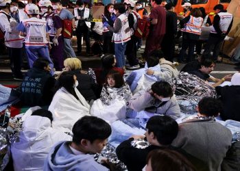 People sit on the street after being rescued, at the scene where dozens of people were injured in a stampede during a Halloween festival in Seoul, South Korea, October 29, 2022. REUTERS/Kim Hong-ji