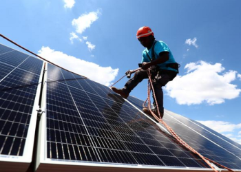 Worker installing solar panels on the roof of a home