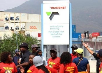 Workers at Transnet walk past ship containers at the Port of Cape Town as they continue on a nationwide strike