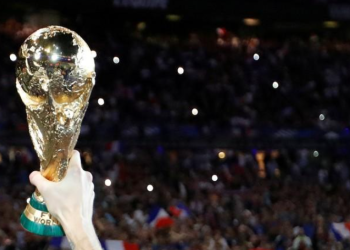 A fan hold a replica of the Soccer World Cup trophy