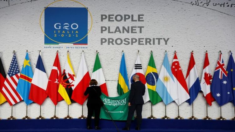 Employees arrange the Saudi Arabian flag during the final preparations before world leaders gather for the official family photograph on day one of the G20 leaders summit at the convention center of La Nuvola, in Rome, October 30, 2021.
