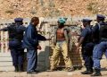 File Image | A suspected illegal miner is questioned by police after he emerged from underground at Johannesburg's oldest gold mine in Langlaagte South Africa