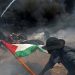 File | Palestinian demonstrators run for cover from Israeli fire and tear gas during a protest
