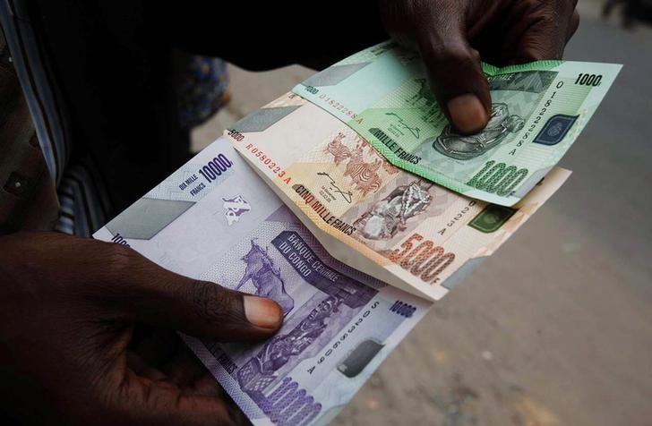 A trader displays Congolese currency bills in the Democratic Republic of Congo's capital Kinshasa.