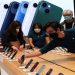FILE PHOTO: An employee arranges Apple iPhones as customer shop at the Apple Store on 5th Avenue shortly after new products went on sale in Manhattan, in New York City, New York, US, March 18, 2022.