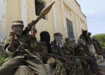 Al-Shabaab soldiers sit outside a building during patrol along the streets of Dayniile district in Southern Mogadishu
