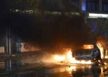 General view of a car on fire during clashes after the World Cup match between Belgium and Morocco