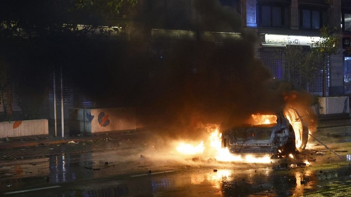 General view of a car on fire during clashes after the World Cup match between Belgium and Morocco