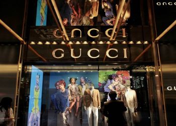 A man looks at a window display outside a Gucci store, part of the Kering group, at Tsim Sha Tsui shopping district in Hong Kong.