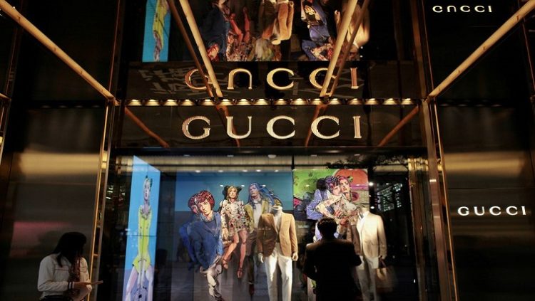 A man looks at a window display outside a Gucci store, part of the Kering group, at Tsim Sha Tsui shopping district in Hong Kong.