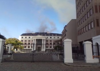 Light smoke starts emerging from the roof of the National Assembly building,  as firefighters are still battling with the blaze at the Old Assembly building, captured at 7:40 AM on 2 January 2022.