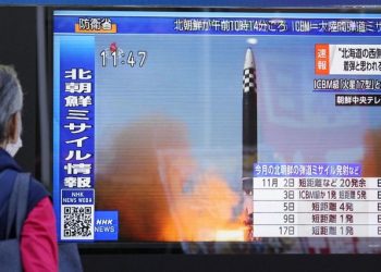 A passer-by looks at a television screen showing a news report about North Korea firing a ballistic missile in Tokyo, Japan November 18, 2022.