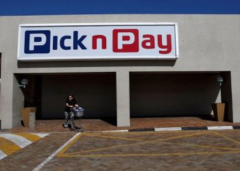 Customer walks beneath the logo of South African supermarket operator Pick n Pay in Cape Town, South Africa, April 26 2016.
