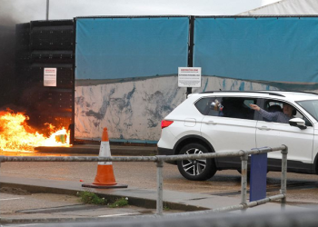 A man throws an object out of a car window next to the Border Force centre after a firebomb attack in Dover, Britain, October 30, 2022. REUTERS/Peter Nicholls