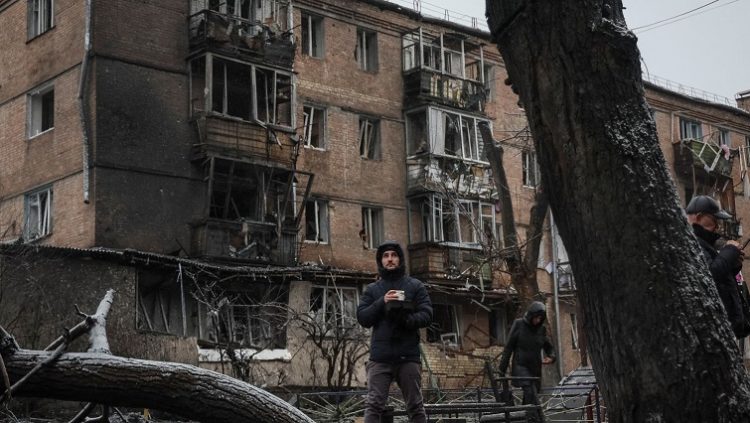 A local resident stands with free hot food near a residential building destroyed by a Russian missile attack, as Russia's attack on Ukraine continues, in the town of Vyshhorod, near Kyiv, Ukraine.