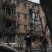 A local resident stands with free hot food near a residential building destroyed by a Russian missile attack, as Russia's attack on Ukraine continues, in the town of Vyshhorod, near Kyiv, Ukraine.
