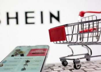 A keyboard and a shopping cart are seen in front of a displayed Shein logo in this illustration picture taken October 13, 2020.