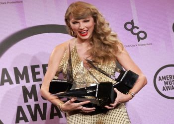 Taylor Swift poses with her awards in the press room during the 2022 American Music Awards at the Microsoft Theater in Los Angeles, California, US, November 20, 2022.