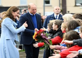 Prince William and his wife Kate interacting with a crowd in the UK