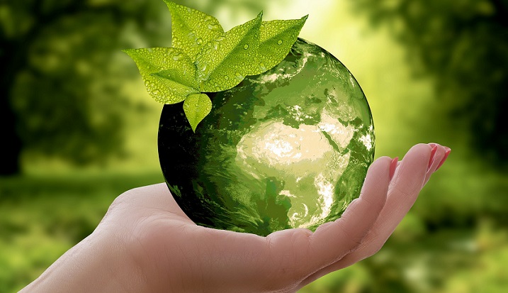 A person's hand and a green planet for illustrative purposes