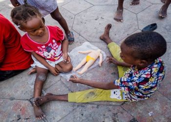 Children play with a broken doll at the Hugo Chavez Square where they shelter from gang war violence in Port-au-Prince, Haiti October 16, 2022.