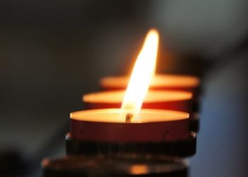 A candle burns at a funeral service