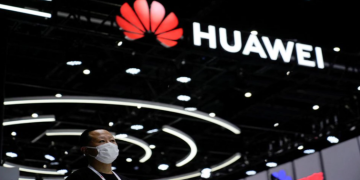 A person stands by a sign of Huawei during World Artificial Intelligence Conference, following the coronavirus disease (COVID-19) outbreak, in Shanghai, China, September 1, 2022.