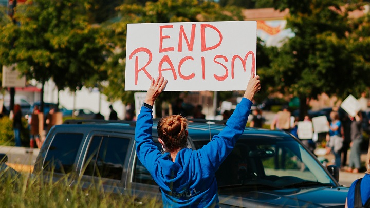 File Photo: A woman holds an anti-racism placard during a protest in the US