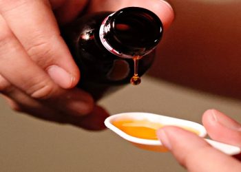 Cough medication poured into a spoon