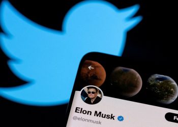 Elon Musk's Twitter account is seen on a smartphone in front of the Twitter logo in this photo illustration taken, April 15, 2022.