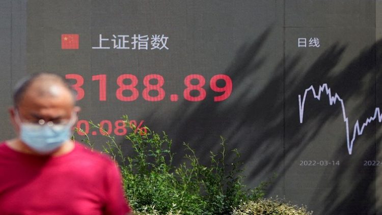 [File Image] : A pedestrian walks past a giant display showing the Shanghai stock index in Shanghai, China