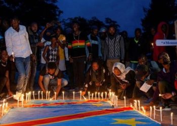 Congolese activists light candles on their national flag during a vigil in memory of the civilians killed in the recent conflict between Armed Forces of the Democratic Republic of the Congo (FARDC) and rebel forces, in Goma, in the North Kivu province of the Democratic Republic of Congo December 5, 2022.