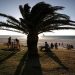 Vistors take in the sunlight at Camps Bay beach as the city experiences a subdued Christmas season after months of lockdowns and worries about the spread of the coronavirus disease.