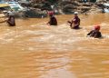 Rescue workers are seen at the Jukskei river on 27 December 2022 in search of missing bodies.