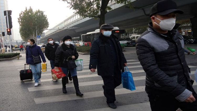 People cross a road amid the coronavirus disease (COVID-19) outbreak, in Wuhan, Hubei province, China December 31, 2022.