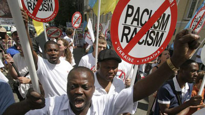 [File Image] A person holds an anti-racism placard.