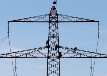 FILE PHOTO: Workers renovate an electricity pylon near Gilching south of Munich October 14, 2014. REUTERS/Michaela Rehle/File Photo