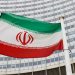 The Iranian flag waves in front of the International Atomic Energy Agency headquarters.