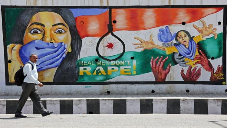 A man walks past a graffiti depicting a message in protest against rape, in Jammu, April 22, 2018. REUTERS/Mukesh Gupta