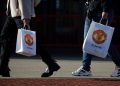 General view as people walk with Manchester United bags outside Old Trafford in Manchester, Britain, November 23, 2022