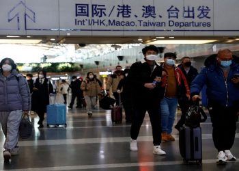 Travellers walk with their luggage at Beijing Capital International Airport, amid the coronavirus disease (COVID-19) outbreak in Beijing, China December 27, 2022.