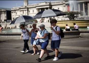People carry umbrellas during a heatwave