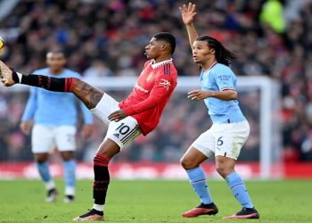Marcus Rashford of Manchester United controls the ball while under pressure from Nathan Ake of Manchester City during the Premier League match between Manchester United and Manchester City at Old Trafford
