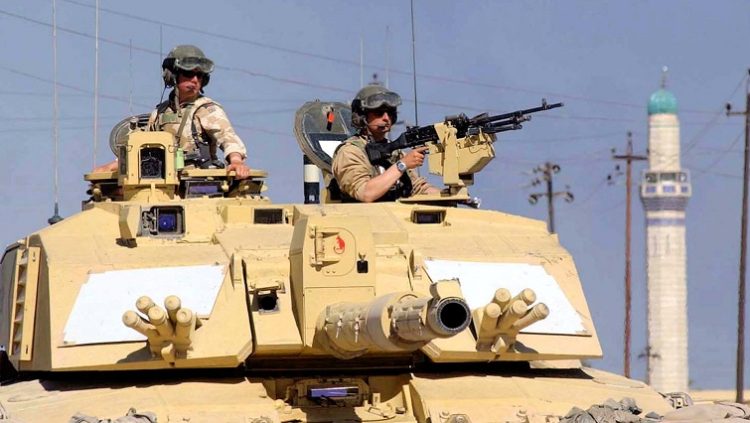 FILE PHOTO: British Sergeant Steve Guy (L) and Corporal Andy Porter keep watch out of a Challenger 2 tank from the 2nd Royal Tank Regiment on patrol in southern Iraq, April 2, 2003. REUTERS/HO/Angus Beaton/File Photo