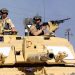 FILE PHOTO: British Sergeant Steve Guy (L) and Corporal Andy Porter keep watch out of a Challenger 2 tank from the 2nd Royal Tank Regiment on patrol in southern Iraq, April 2, 2003. REUTERS/HO/Angus Beaton/File Photo