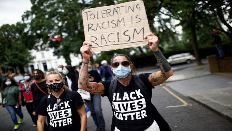 [File photo]  An anti-racism activist holds a placard during a protest.